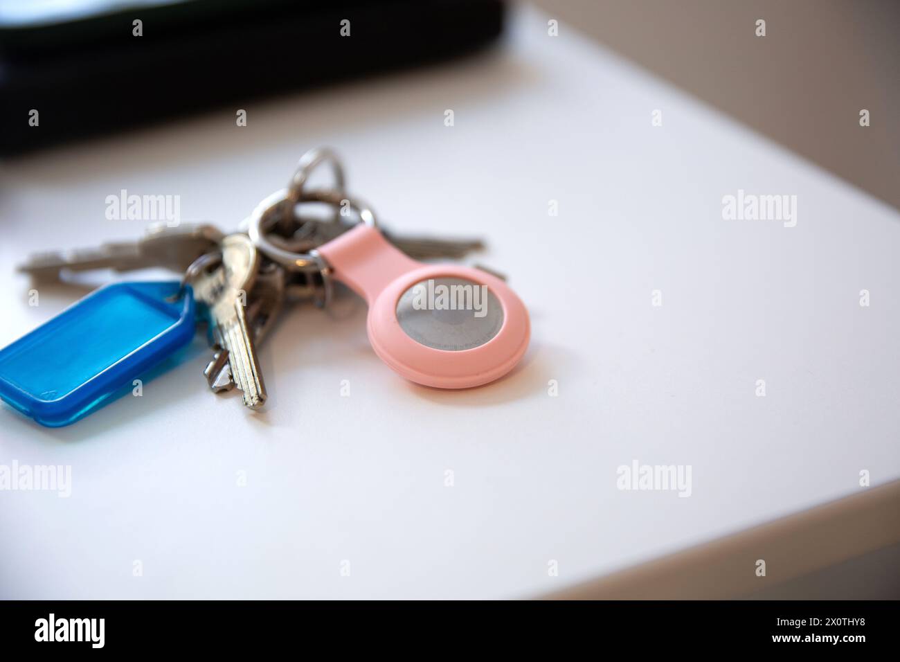 Gros plan des clés avec un AirTag pomme sur la table blanche Banque D'Images