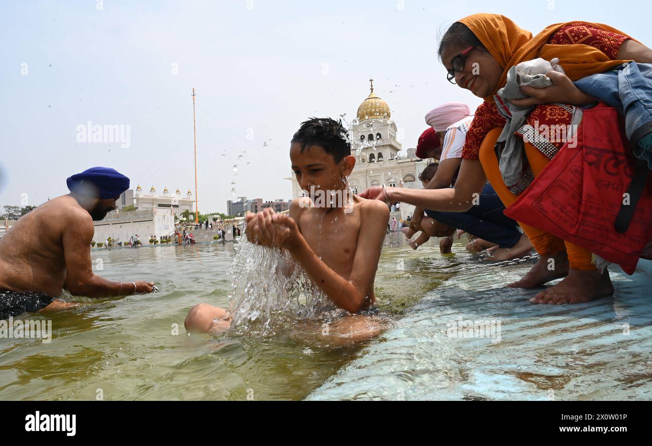 NEW DELHI, INDE - 13 AVRIL : les dévots se baignent dans l'étang sacré de Gurudwara Bangla Sahib à l'occasion du festival Baisakhi, le 13 avril 2024 à New Delhi, Inde. Baisakhi ou Vaisakhi, une fête populaire du printemps qui marque le premier jour du mois du Vaisakh, est célébrée avec beaucoup d'enthousiasme parmi les communautés hindoue, sikhe et bouddhiste. C'est le début du nouvel an pendjabi et sikh qui est célébré dans toute l'Inde, en particulier au Punjab et dans le nord de l'Inde. Le Baisakhi est observé le 13 avril de cette année, annonçant le début de la saison des récoltes au Pendjab. Il tombe le premier jour de Hin Banque D'Images