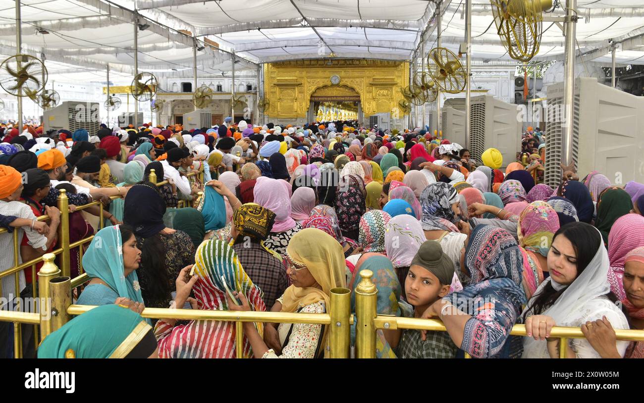 AMRITSAR, INDE - 13 AVRIL : les dévots payent l'obéissance à l'occasion du festival Baisakhi au Temple d'Or le 13 avril 2024 à Amritsar, Inde. Baisakhi ou Vaisakhi, une fête populaire du printemps qui marque le premier jour du mois du Vaisakh, est célébrée avec beaucoup d'enthousiasme parmi les communautés hindoue, sikhe et bouddhiste. C'est le début du nouvel an pendjabi et sikh qui est célébré dans toute l'Inde, en particulier au Punjab et dans le nord de l'Inde. Le Baisakhi est observé le 13 avril de cette année, annonçant le début de la saison des récoltes au Pendjab. Il tombe le premier jour de l'année solaire hindoue. ( Banque D'Images