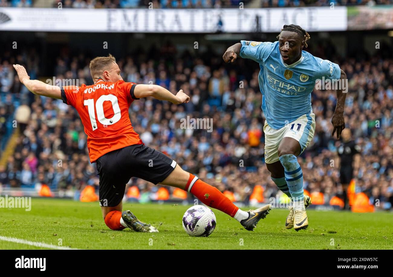 (240414) -- MANCHESTER, 14 avril 2024 (Xinhua) -- Jeremy Doku (R) de Manchester City dépasse Cauley Woodrow de Luton Town lors du match de premier League anglais entre Manchester City et Luton Town à Manchester, Grande-Bretagne, le 13 avril 2024. (XINHUA) POUR USAGE ÉDITORIAL UNIQUEMENT. NON DESTINÉ À LA VENTE POUR DES CAMPAGNES DE MARKETING OU DE PUBLICITÉ. AUCUNE UTILISATION AVEC DES FICHIERS AUDIO, VIDÉO, DONNÉES, LISTES DE PRÉSENTOIRS, LOGOS DE CLUB/LIGUE OU SERVICES « EN DIRECT » NON AUTORISÉS. UTILISATION IN-MATCH EN LIGNE LIMITÉE À 45 IMAGES, PAS D'ÉMULATION VIDÉO. AUCUNE UTILISATION DANS LES PARIS, LES JEUX OU LES PUBLICATIONS DE CLUB/LIGUE/JOUEUR UNIQUE. Banque D'Images