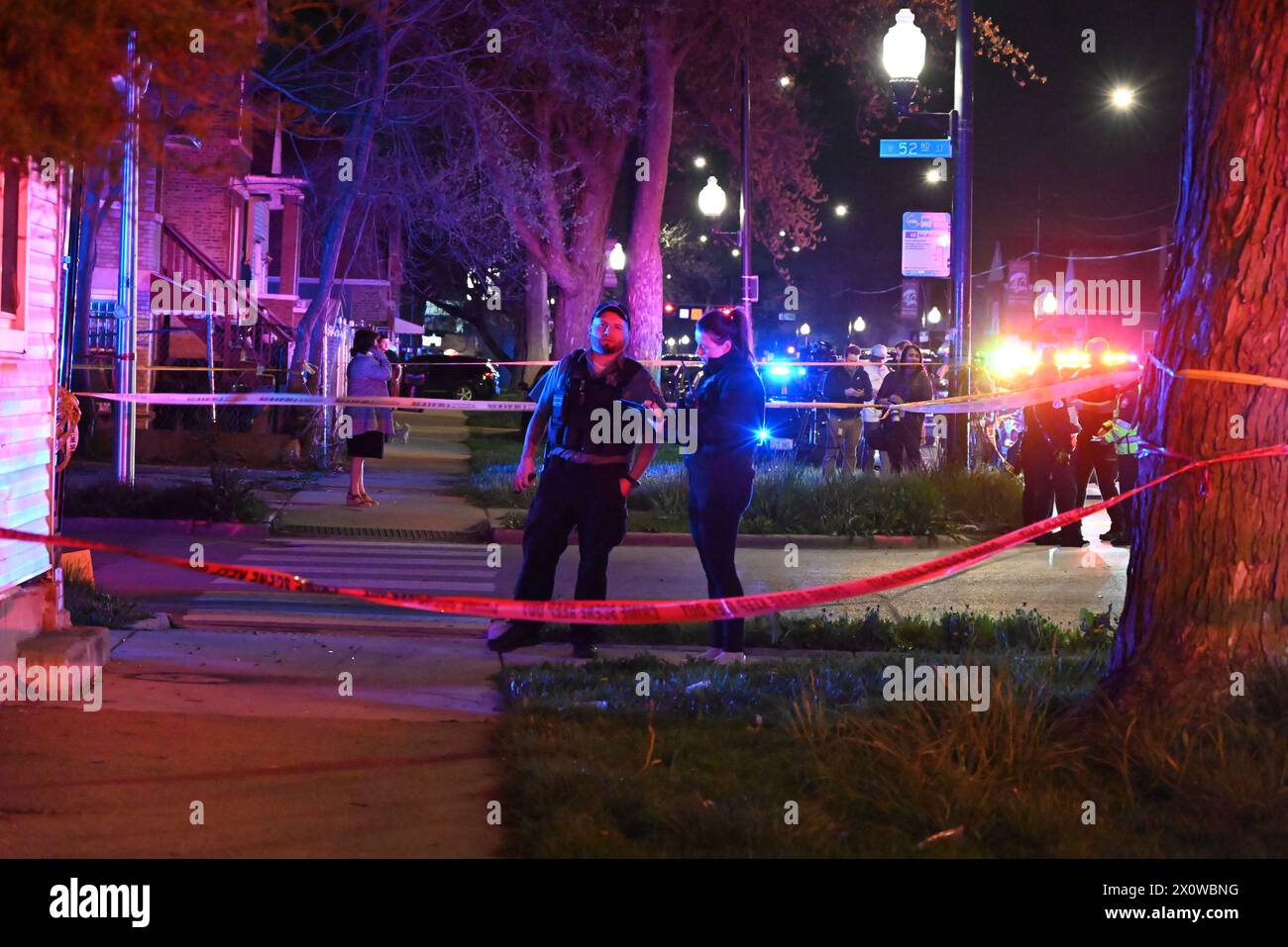 La police de Chicago, les ambulances et les véhicules d'urgence se précipitent sur les lieux d'une fusillade de masse. Huit personnes ont été abattues, dont cinq adultes et trois enfants, dans le quartier de West 52nd Street à Chicago. Les adultes qui ont été abattus varient en âge de 19 à 40 ans. Un homme hispanique de 1 an a été abattu plusieurs fois et se trouve dans un état critique, un homme hispanique de 7 ans a été abattu plusieurs fois et se trouve dans un état critique, une femme hispanique de 7 ans a reçu une balle dans la tête et a été déclarée morte. Aucun suspect n'est en détention pour le moment et la fusillade semble être liée à un gang. Banque D'Images