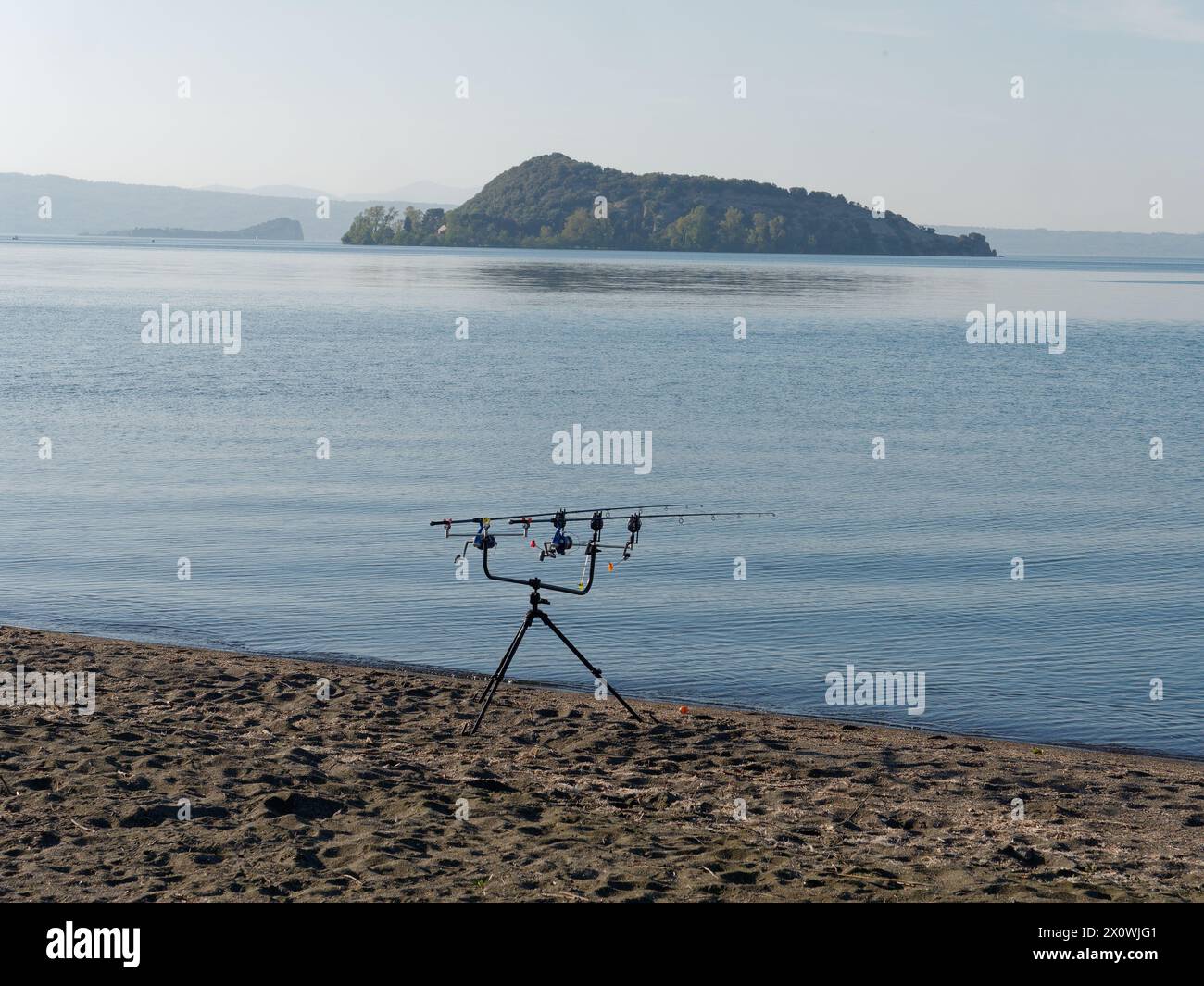 Île sur le lac Bolsena près de la ville de Marta avec des cannes à pêche sur une plage de sable volcanique, province de Viterbe, région du Latium, Italie. 13 avril 2024 Banque D'Images