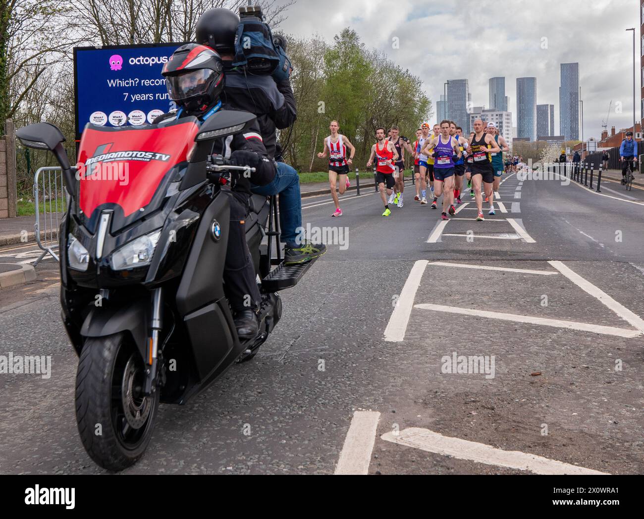 Manchester, Royaume-Uni. 14 avril 2024. Coureurs d'élite avec vélo caméra Manchester Marathon 2024. Sur Chester Road juste après la marque de 1,5 kilomètre. Bâtiments de grande hauteur du centre de Manchester. Photo : Garyroberts/worldwidefeatures.com crédit : GaryRobertsphotography/Alamy Live News Banque D'Images