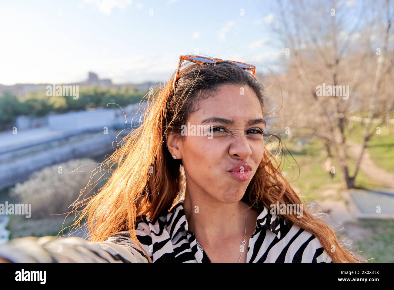 Drôle de femme latine prenant selfie pour les médias sociaux Banque D'Images