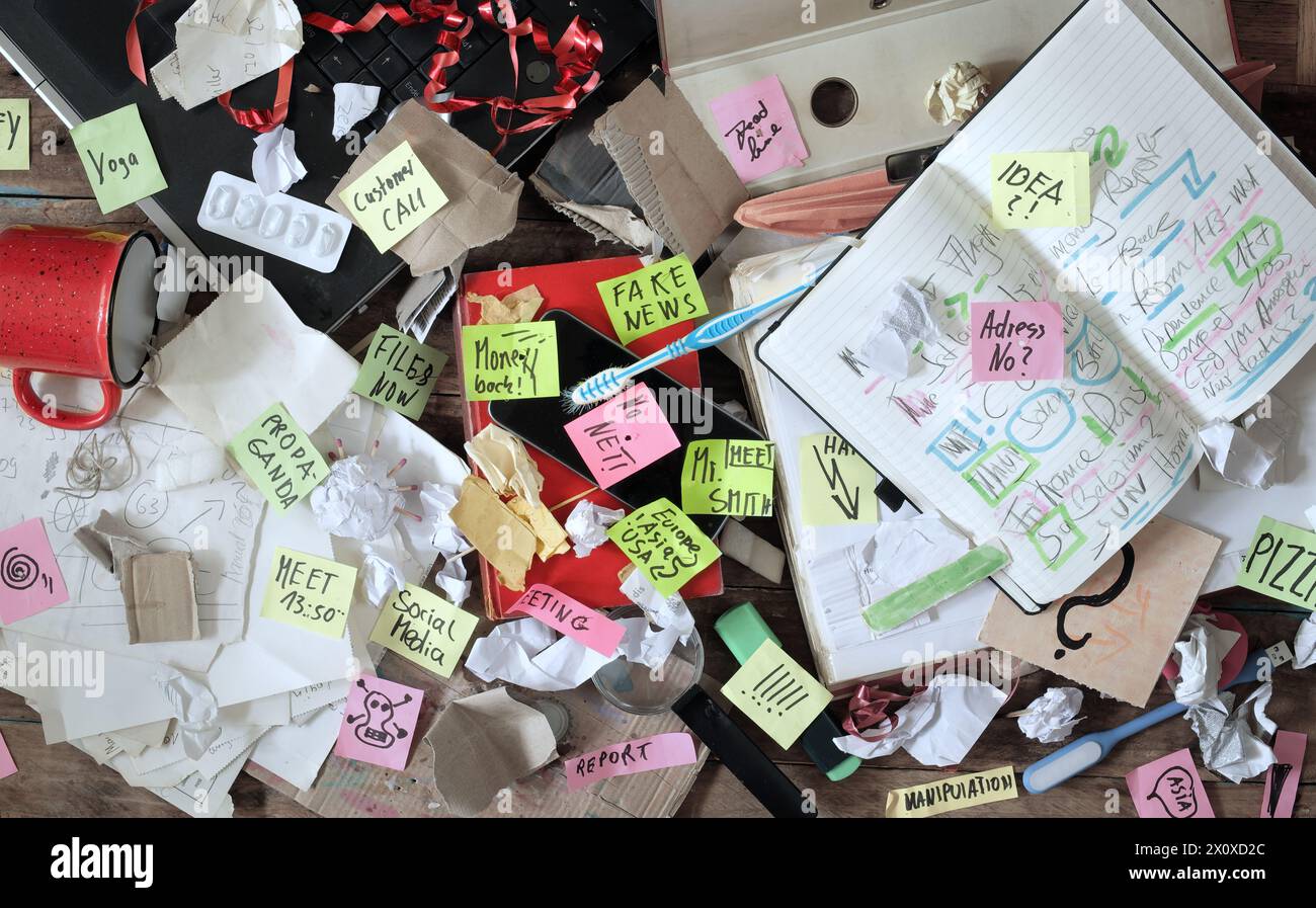 Lieu de travail désordonné, bureau chaotique, surchargé, bureaucratie, concept de bande rouge avec bureau grungy, notes adhésives et diverses fournitures de bureau, désordre chaotique. Banque D'Images