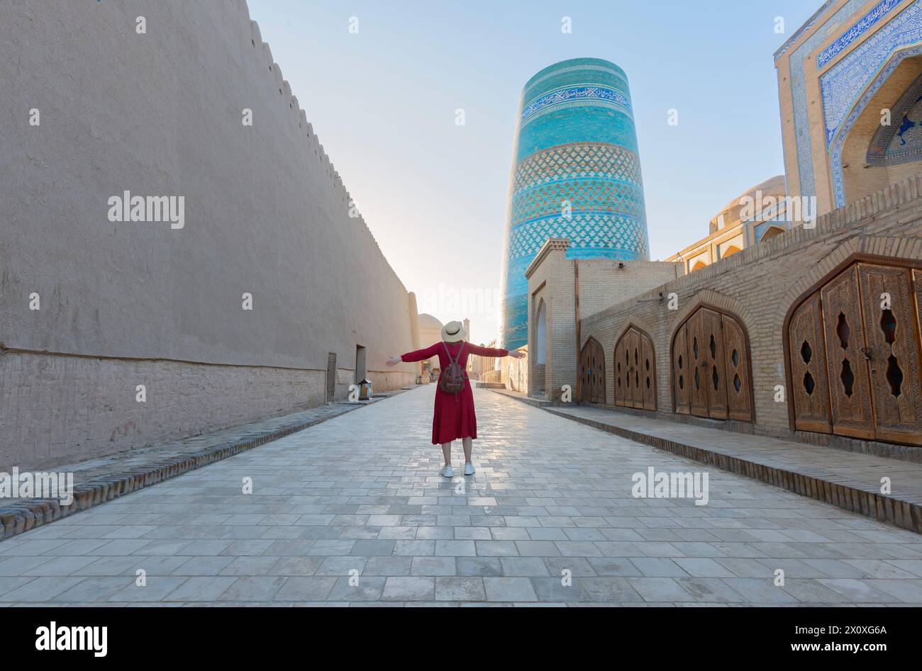 Jeune dame prenant une photo des bâtiments orientaux dans la ville antique d'Itchan Kala. Khiva, Ouzbékistan Banque D'Images