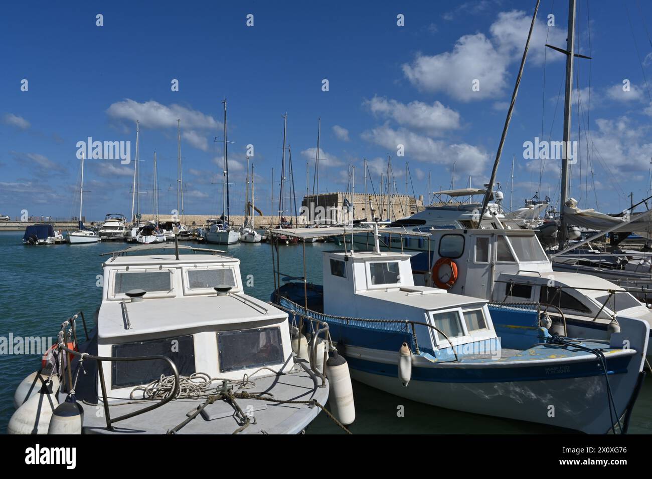 Bateaux de pêche avec coques en bois bleues et blanches dans le port grec d'Héraklion près du centre-ville pendant l'été. Banque D'Images