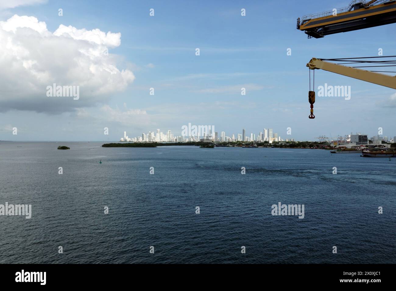 Une silhouette lointaine de Carthagène, Colombie, avec ses bâtiments blancs et hauts modernes vus du terminal à conteneurs dans le port maritime avec des grues. Banque D'Images