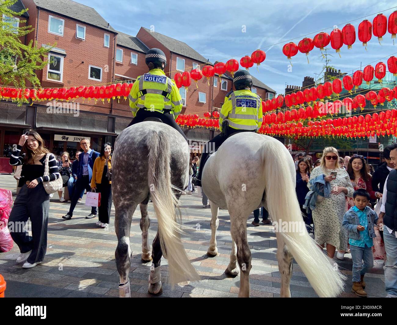 Deux officiers de police montés ont rencontré des chevaux à travers chinatown soho centre de londres angleterre Royaume-Uni Banque D'Images