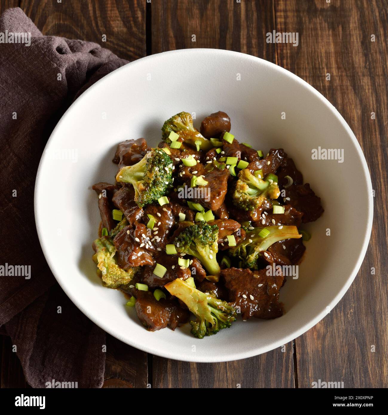 Boeuf avec brocoli dans un bol sur fond en bois. Viande de bœuf finement tranchée avec brocoli rôti. Vue rapprochée Banque D'Images