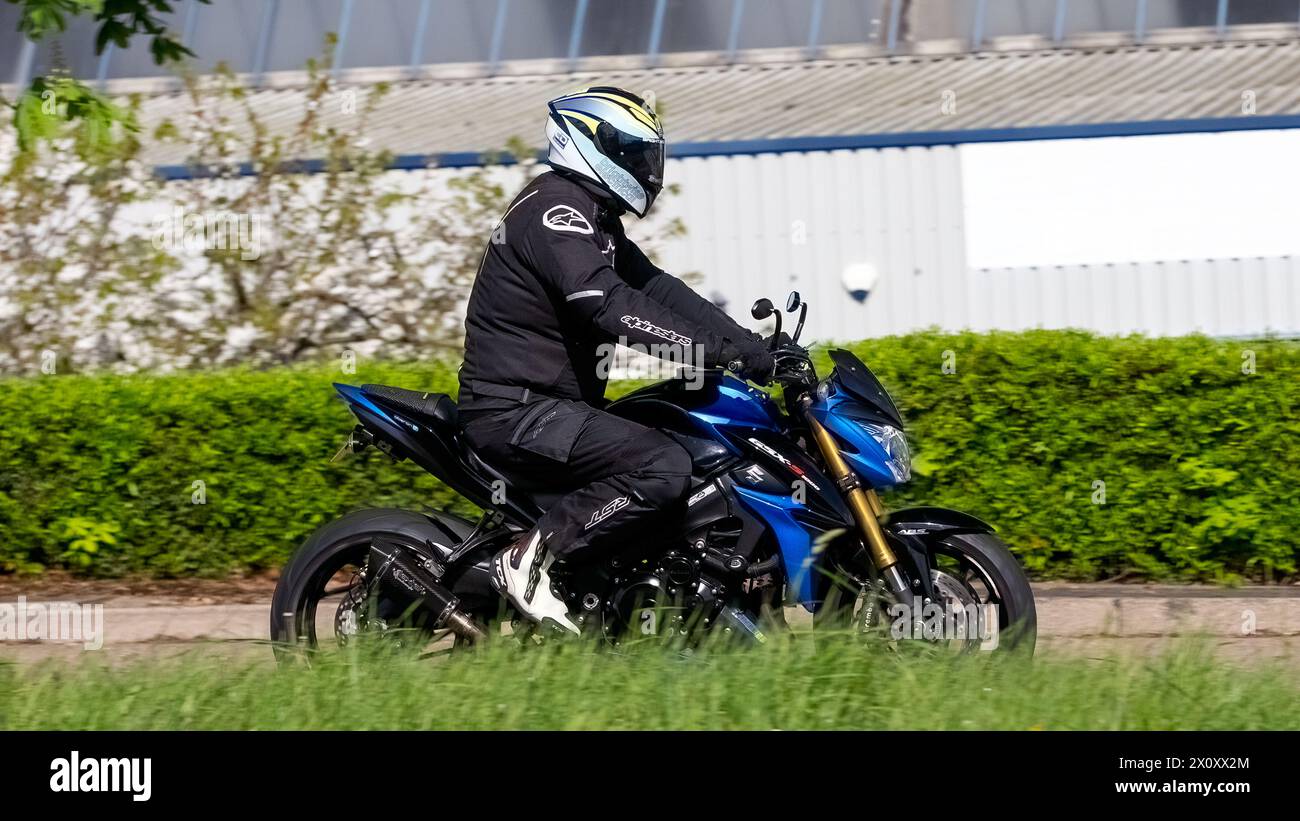 Milton Keynes, Royaume-Uni- 14 avril 2024 : moto Suzuki bleue voyageant sur une route britannique Banque D'Images