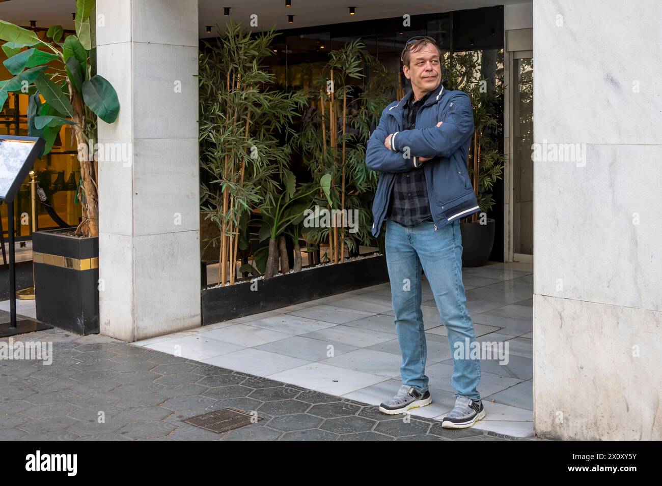 Portrait d'un homme âgé de 50-55 ans sur un fond urbain neutre, regardant loin. Banque D'Images