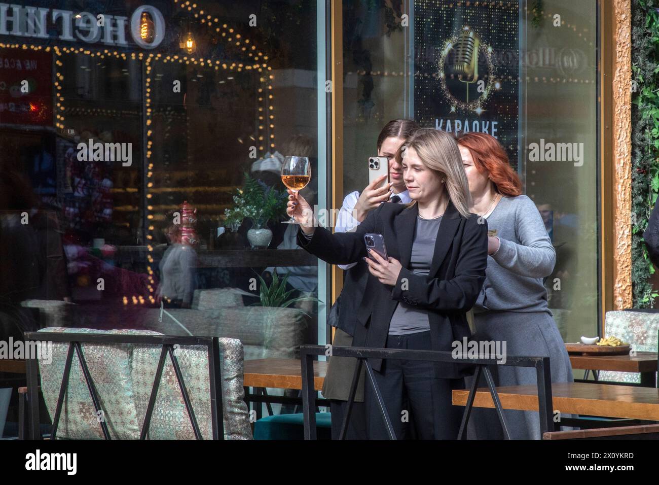 Moscou, Russie. 14 avril 2024. Les femmes sont photographiées dans un café en plein air un jour de congé sur la rue piétonne Arbat dans le centre de Moscou, Banque D'Images