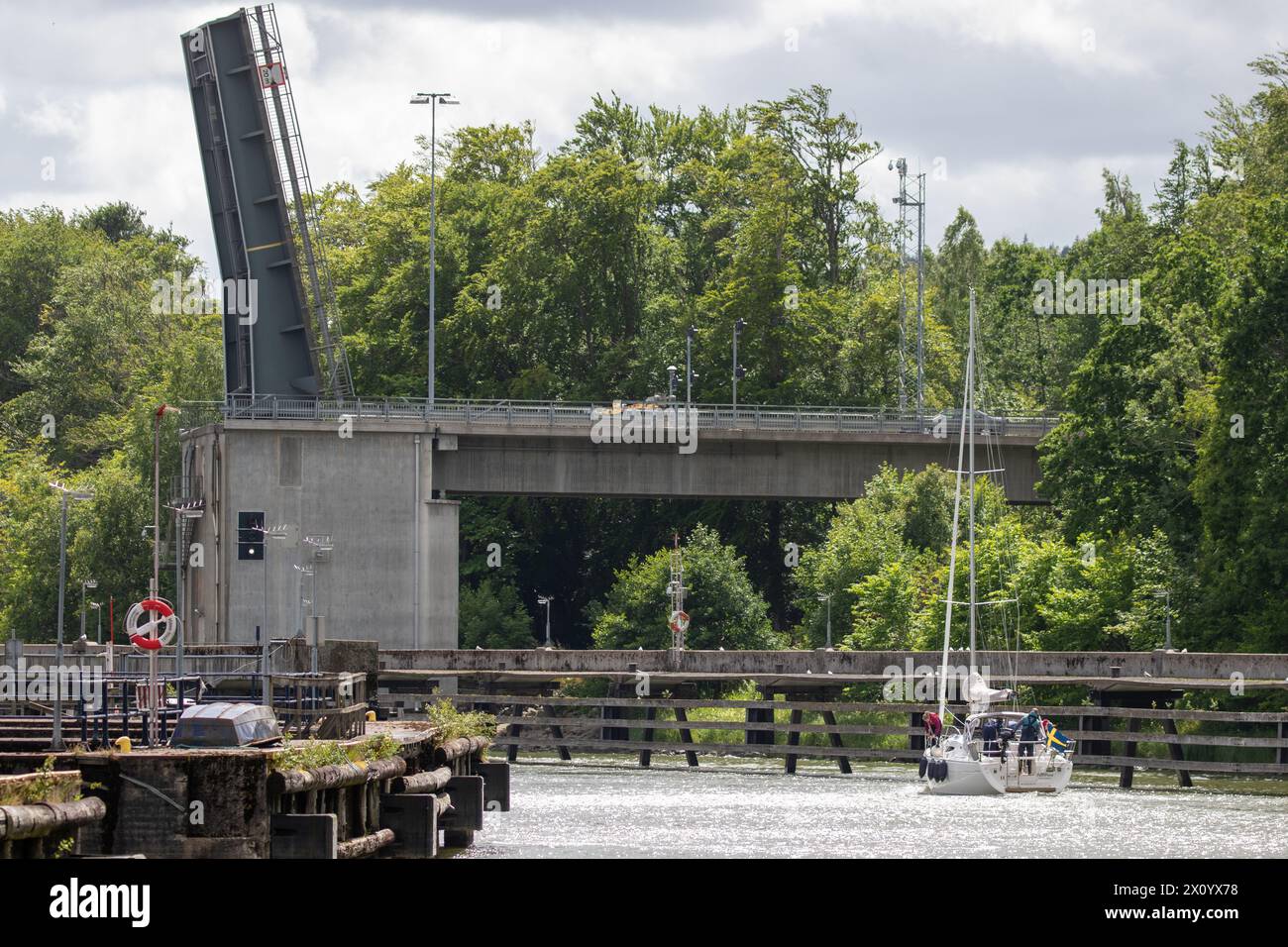 Un voilier est sur le point de passer un pont ouvert dans une rivière dans l'ouest de la Suède Banque D'Images
