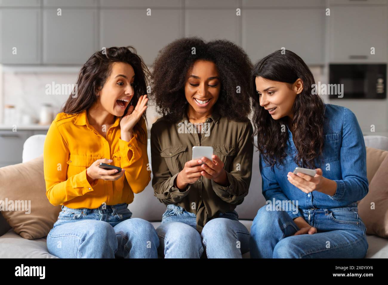 Amis réagissant au contenu du smartphone, font la fête à la maison Banque D'Images