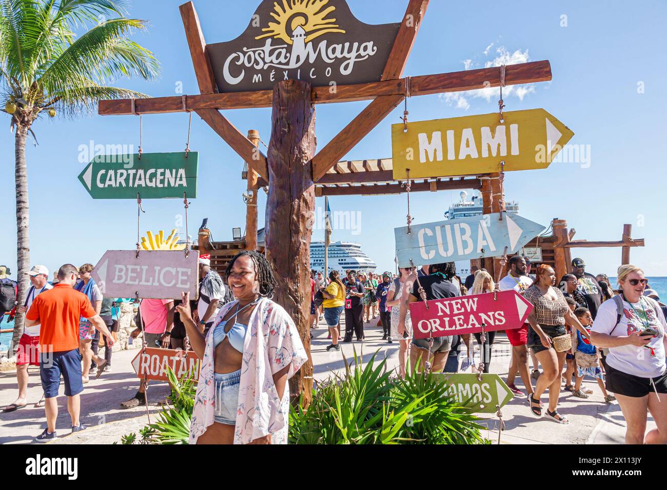 Costa Maya Mexique, Port de croisière, navire Norwegian Joy Cruise Line, itinéraire de 7 jours de la mer des Caraïbes, passager de femme noire posant, signes directions lointaine citie Banque D'Images