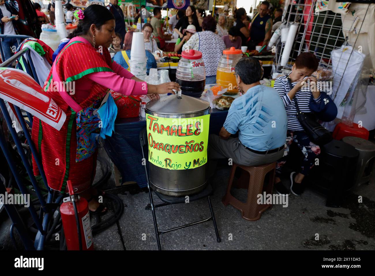Mexico, Mexique. 14 avril 2024. Une femme assiste à un stand de nourriture à vendre lors de la clôture du Festival de la langue maternelle dans le Zocalo de Mexico. Les habitants des villes et des quartiers originaires de la République mexicaine offrent divers produits à la vente, y compris l'artisanat, la nourriture, et un nombre infini de produits traditionnels du pays. (Photo de Gerardo Vieyra/NurPhoto)0 crédit : NurPhoto SRL/Alamy Live News Banque D'Images