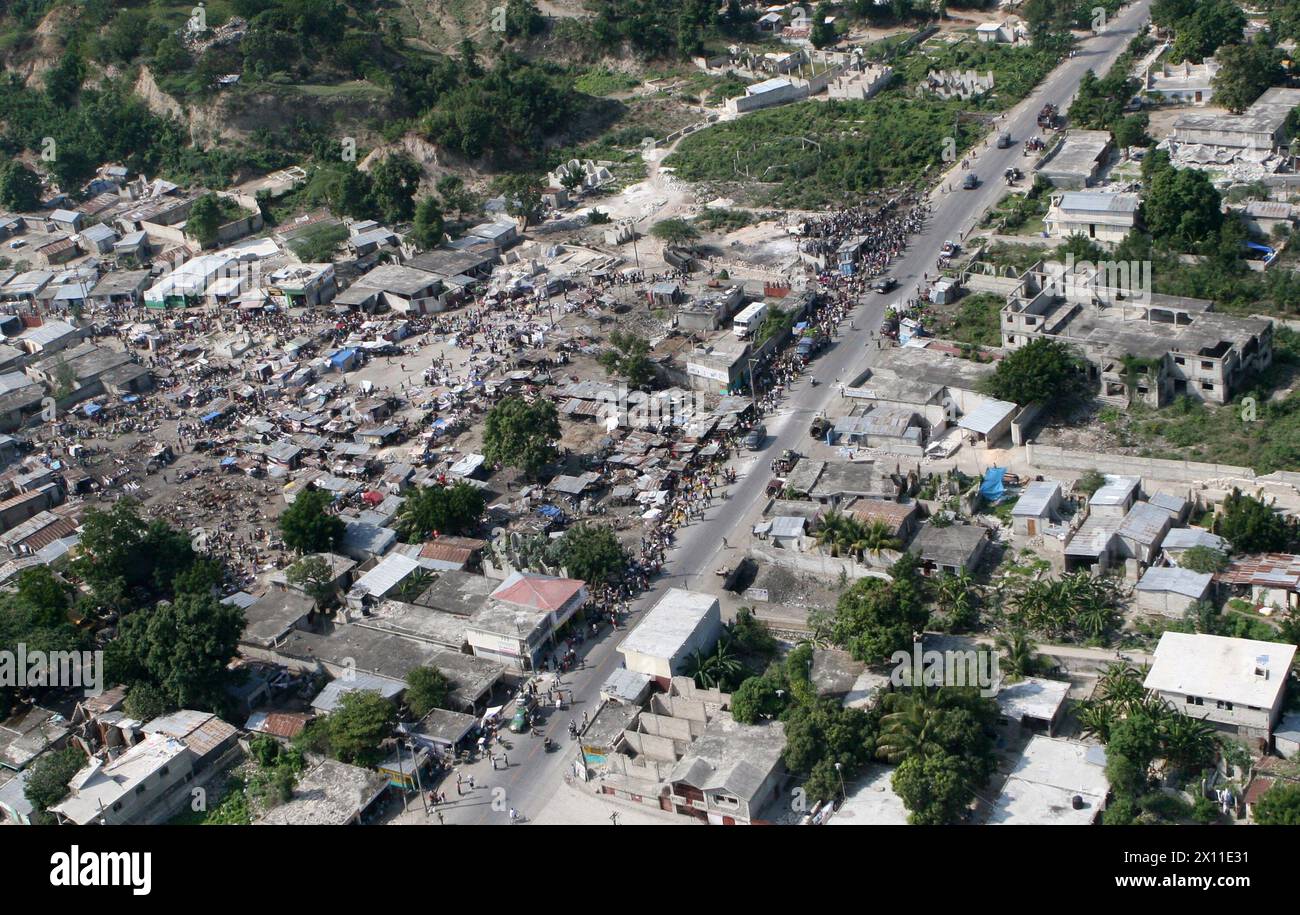 Les victimes du tremblement de terre se rassemblent dans de grandes zones dans des maisons de travail à Léogane, Haïti, 20 janvier 2010. La 22e unité expéditionnaire des Marines est une force capable de missions multiples composée de l'élément de combat aérien, de l'escadron d'hélicoptères lourds des Marines 461 (renforcé) ; de l'élément de combat logistique, du bataillon de logistique de combat 22 ; de l'élément de combat terrestre, de l'équipe de débarquement du bataillon, du 3e bataillon, du 2e régiment de Marines; et son élément de commande. Banque D'Images