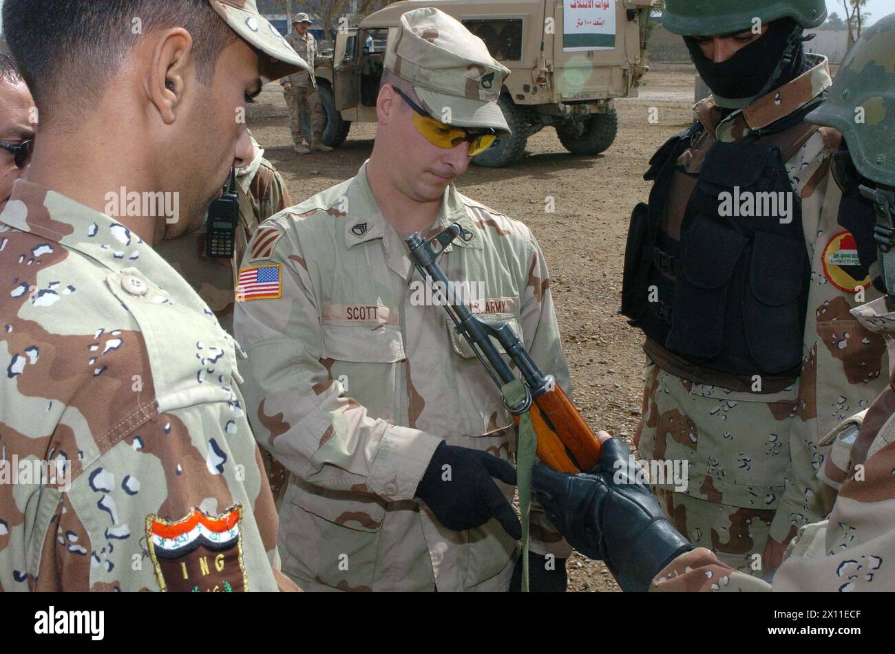 Le sergent d'état-major Mark Scott, 3/7 Cav., inspecte un fusil de soldat de l'armée irakienne avec le sergent de peloton de soldat. Les soldats de l'IA se sont alignés pour les vérifications avant combat avant de partir en patrouille de sécurité du Camp Volunteer, Irak CA. 24 janvier (2003 date par métadonnées) Banque D'Images