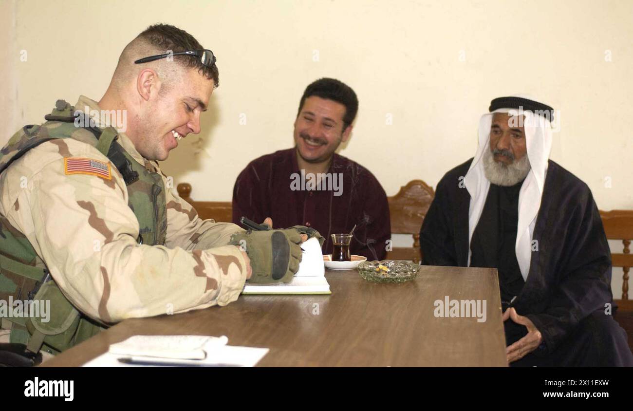 Le sergent Michael Marker, de l’État de Washington, parle à un agriculteur de ses récoltes dans un centre d’opérations militaires civiles à Hamman Al Alil Irak. Marker appartient au 1er peloton, compagnie B, 5e bataillon, 20e régiment d'infanterie, 3e brigade, 2nd Infantry Division CA. 03 juin 2004 Banque D'Images