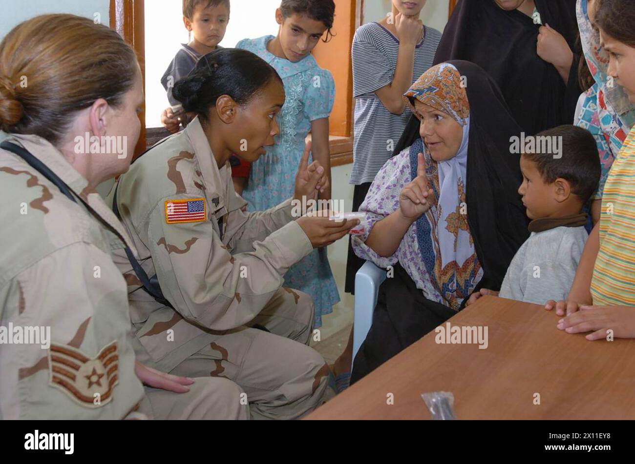 Des médecins de l'armée et de l'armée de l'air expliquent à une irakienne combien de médicaments prendre pendant un projet d'action civile médicale du commandement du soutien du 13e corps dans le village de Bakr, en Californie. 2004 Banque D'Images