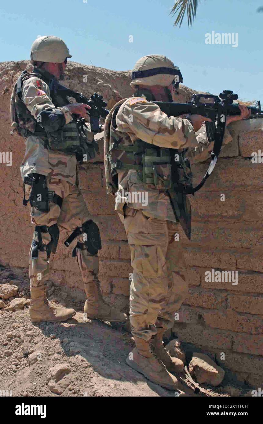 Soldats de l'équipe de combat de la 3e brigade, 1re division d'infanterie, à la recherche d'armes dans un quartier proche de la base opérationnelle avancée Normandie (Irak) CA. 7 août 2004 Banque D'Images