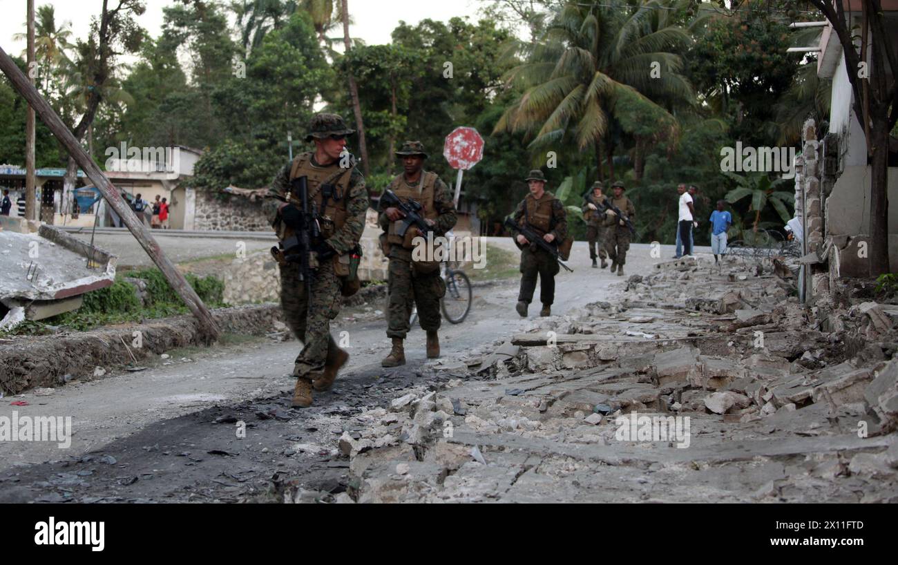 Les Marines de la Compagnie Lima, de l’équipe de débarquement du bataillon, du 3e bataillon, du 2e régiment de Marines, de la 22e unité expéditionnaire des Marines, effectuent une patrouille de reconnaissance dans les rues de la région Ouest d’Haïti, le 24 janvier 2010. La compagnie s'est envolée dans la ville de Léogane plus tôt dans la journée, a établi un poste de commandement et a effectué des patrouilles de reconnaissance pour évaluer la zone afin de commencer des missions d'aide humanitaire et de secours en cas de catastrophe pour les populations des environs. Banque D'Images