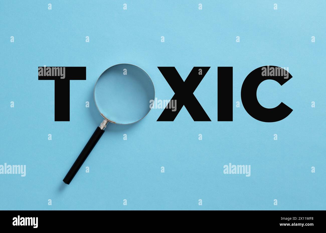 Le mot toxique avec loupe. Analyse de la toxicité. Révéler des relations toxiques dans votre vie ou votre travail. Banque D'Images