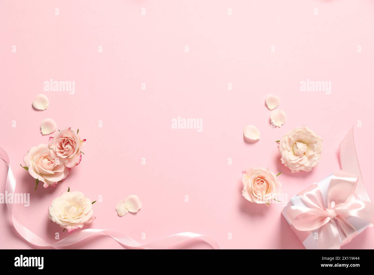 Bonne fête des mères. Belles fleurs, boîte-cadeau et ruban sur fond rose, plat. Espace pour le texte Banque D'Images