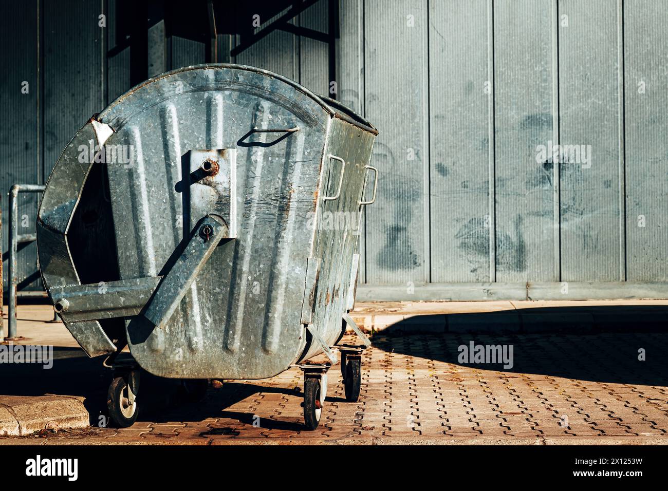 Conteneur à déchets métallique devant le bâtiment industriel, mise au point sélective Banque D'Images