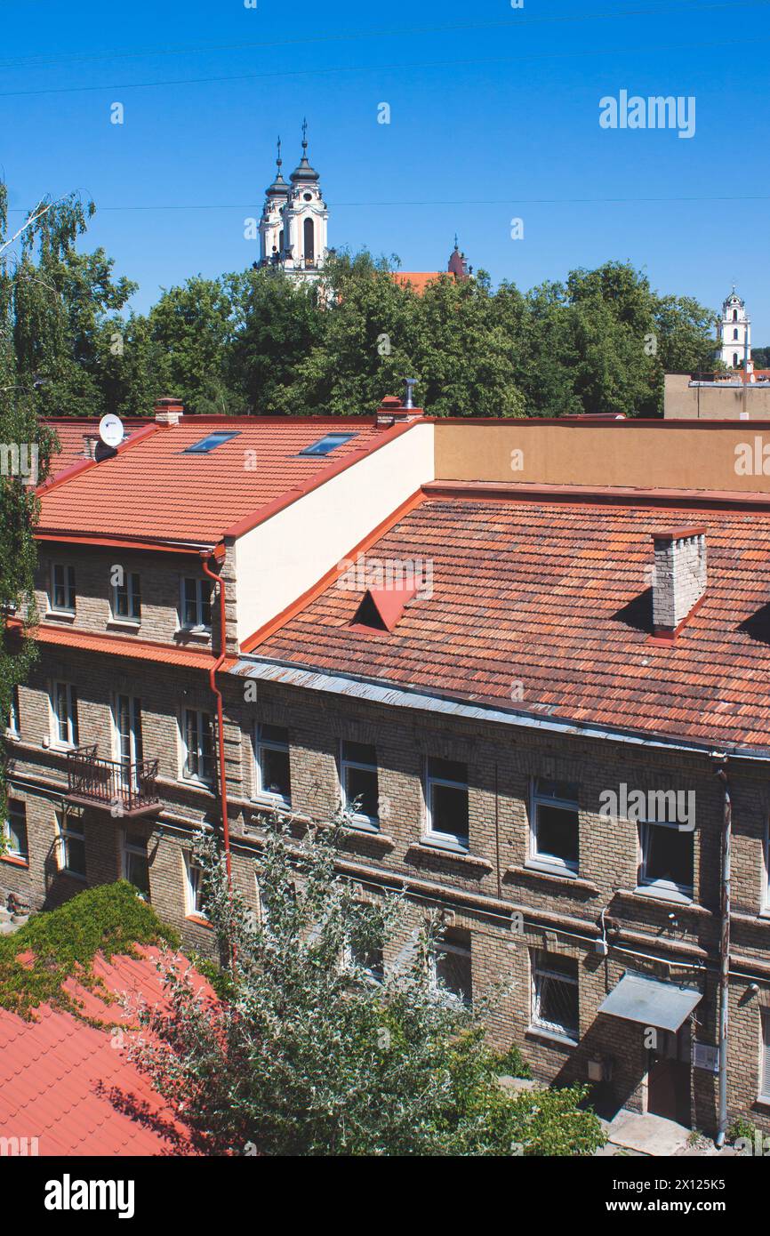 Toits de tuiles rouges des maisons et des églises à l'arrière, format vertical. Architecture de la vieille ville européenne Banque D'Images