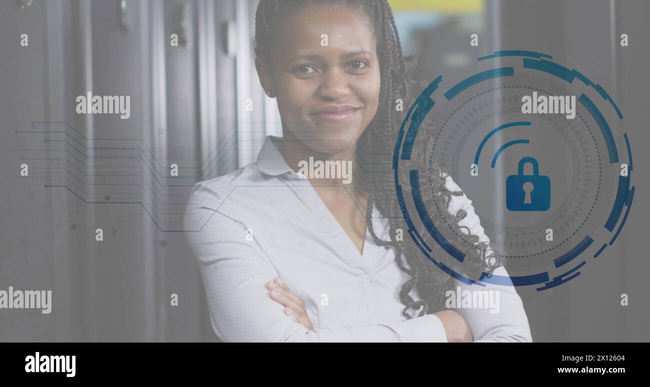 Image d'une icône de cadenas et d'une ingénieure afro-américaine debout dans un centre de données Banque D'Images