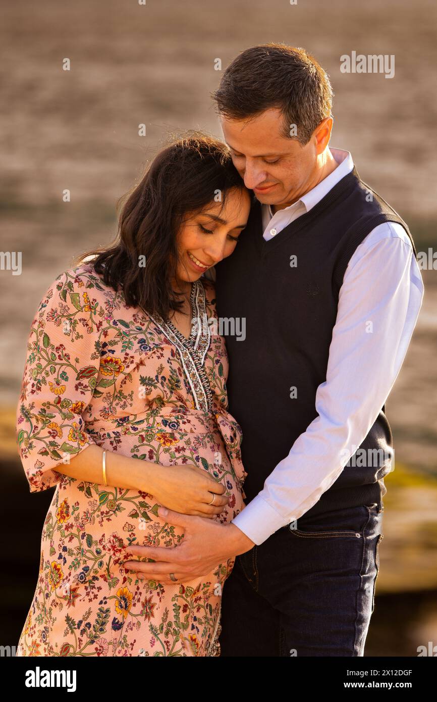 Gros plan d'une maman et papa regardant le ventre enceinte Banque D'Images