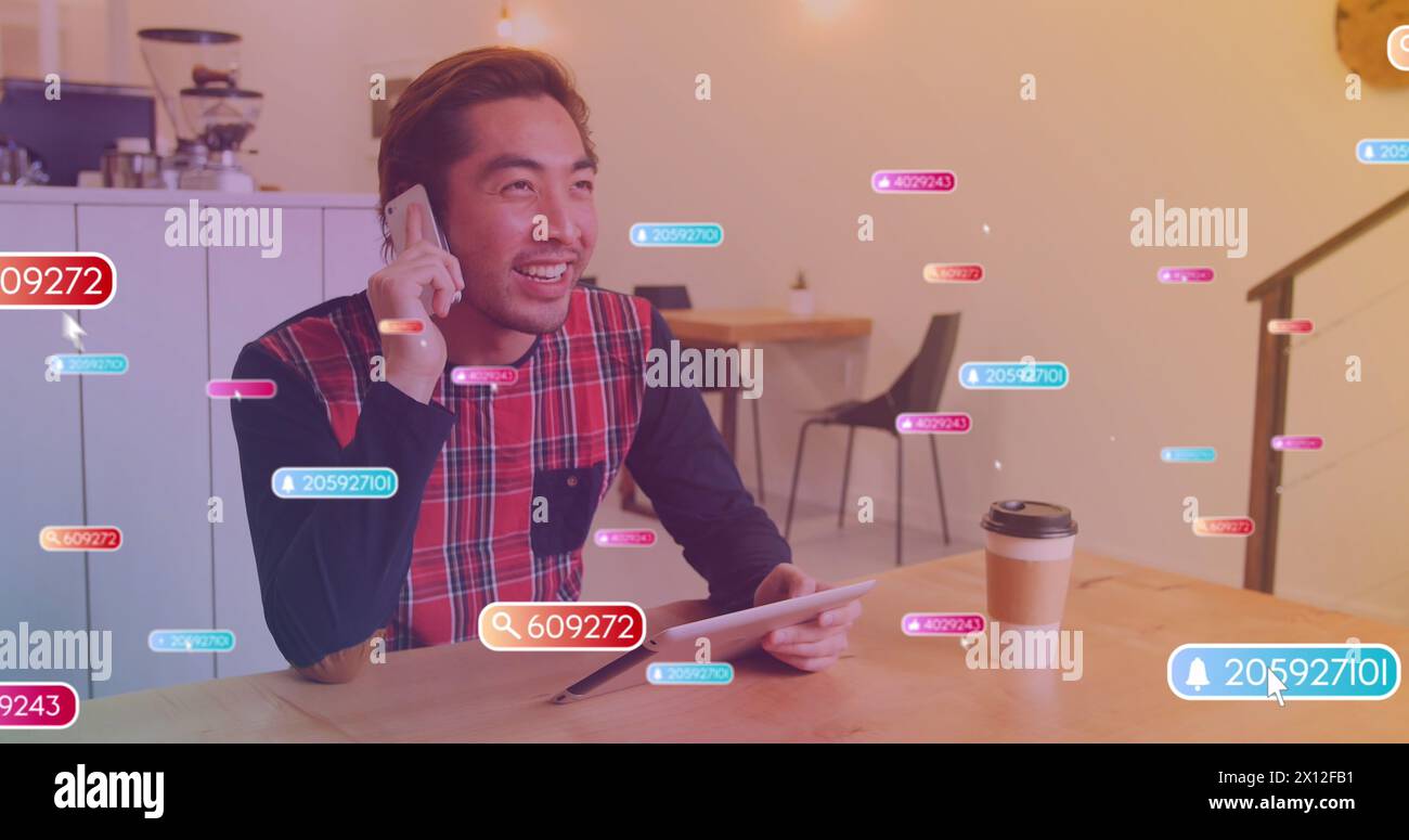 Image d'icônes de médias sur homme asiatique heureux à l'aide d'un smartphone Banque D'Images