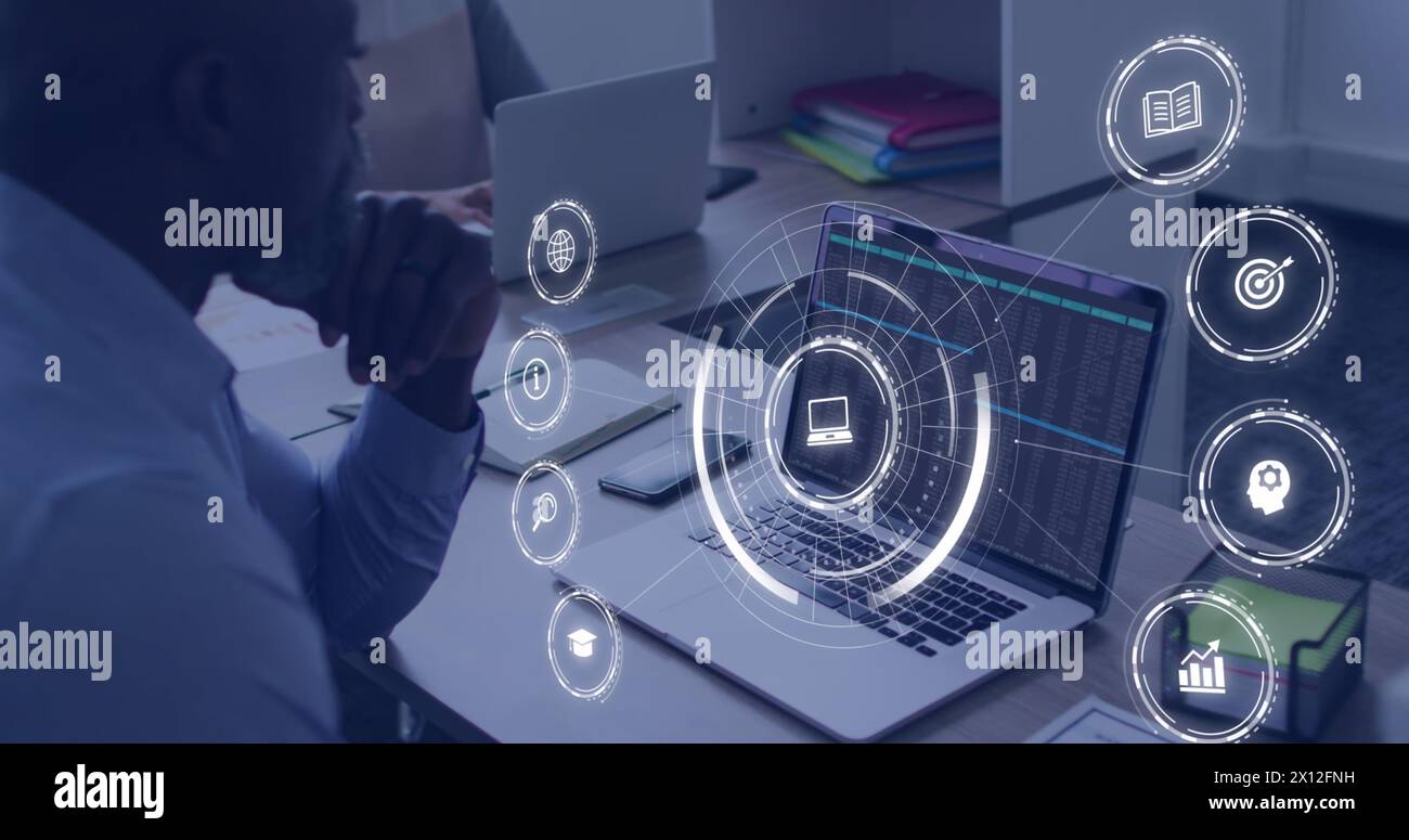 Image d'icônes d'éducation tombant au-dessus des hommes afro-américains utilisant un ordinateur portable Banque D'Images