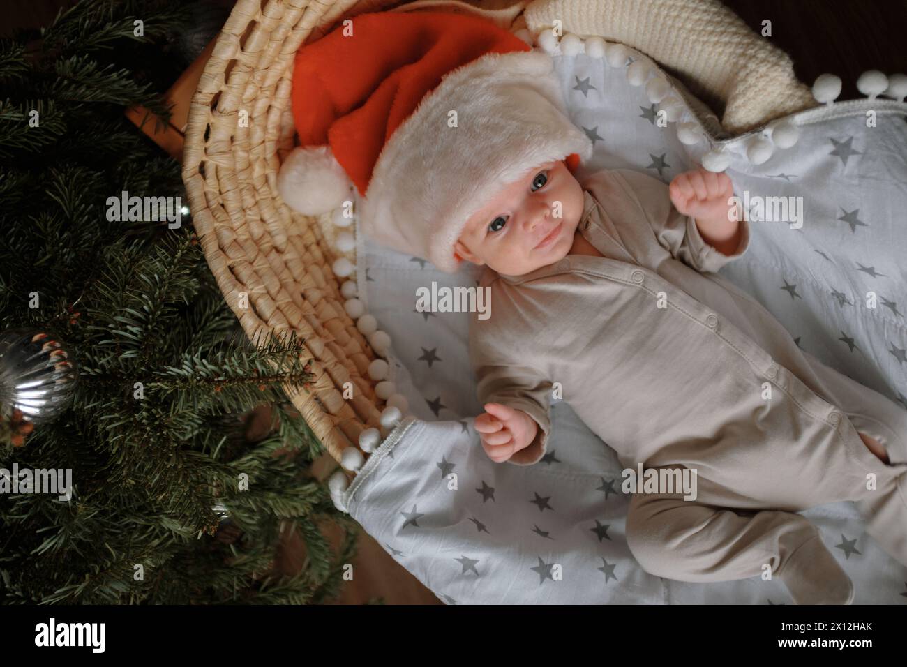 Le nouveau-né est couché dans un berceau, portant un chapeau de Père Noël. Banque D'Images