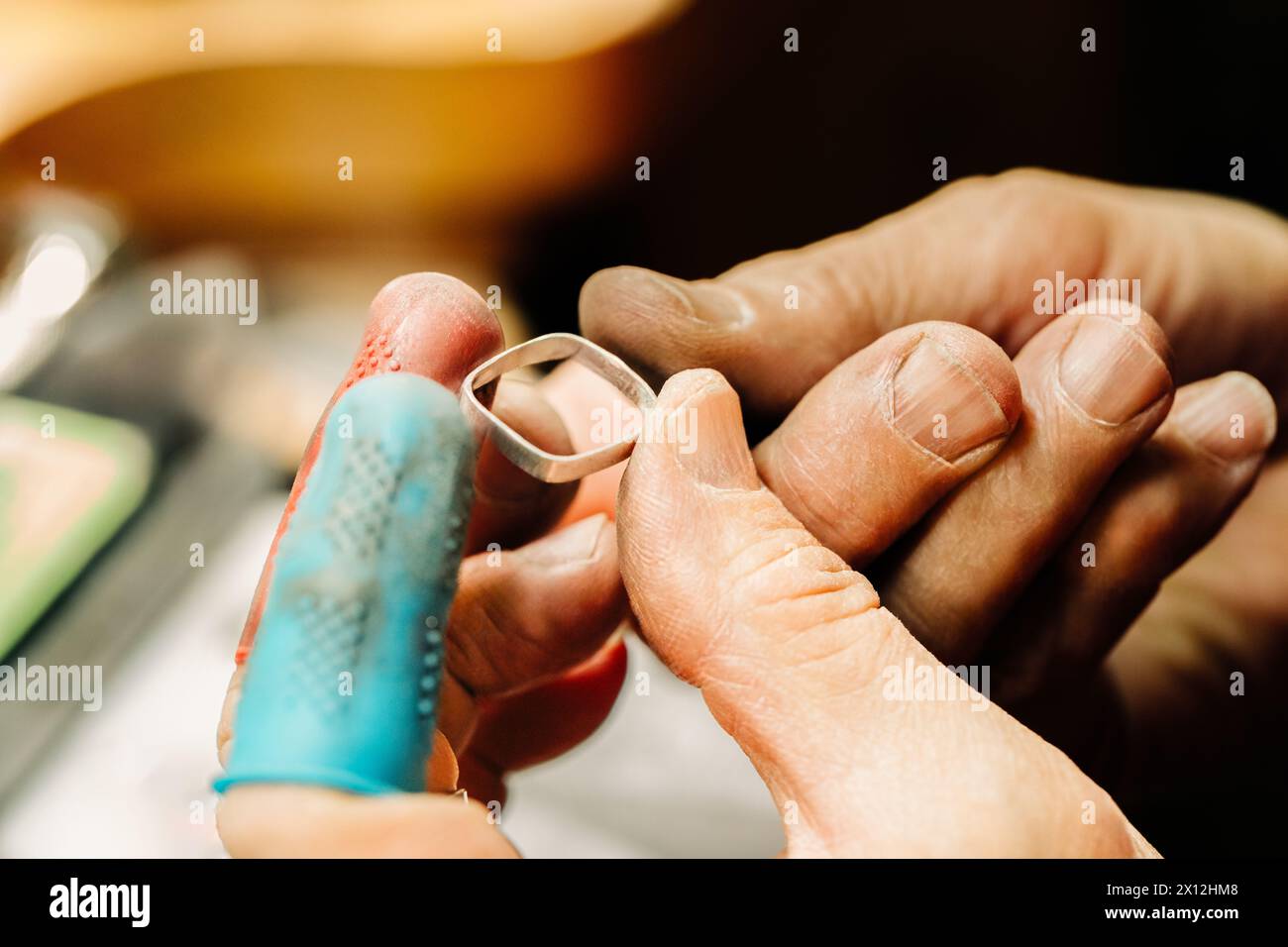 Gros plan des mains de bijoutiers inspectant la lunette en argent fin Banque D'Images