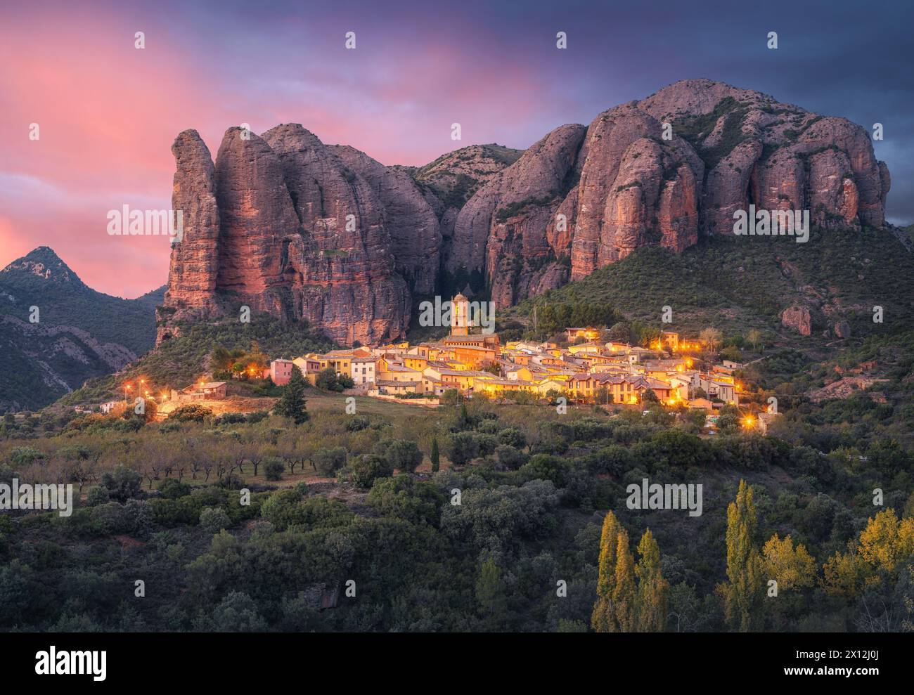 Village d'Aguero et formation rocheuse de Mallos de Aguero à Sunset, Espagne Banque D'Images