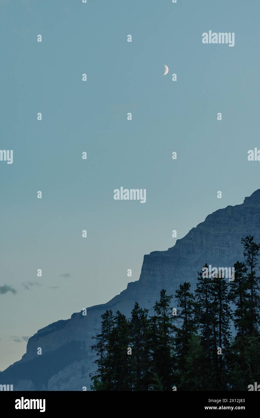 Crépuscule lever de lune au-dessus de la silhouette de montagne Banque D'Images