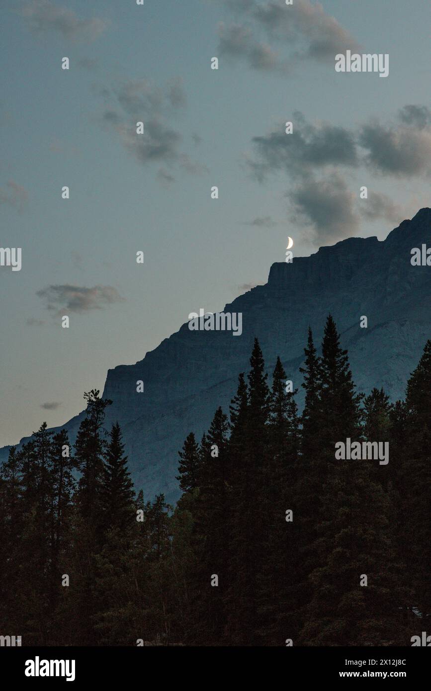 Croissant de lune au-dessus de la silhouette de la montagne Banque D'Images