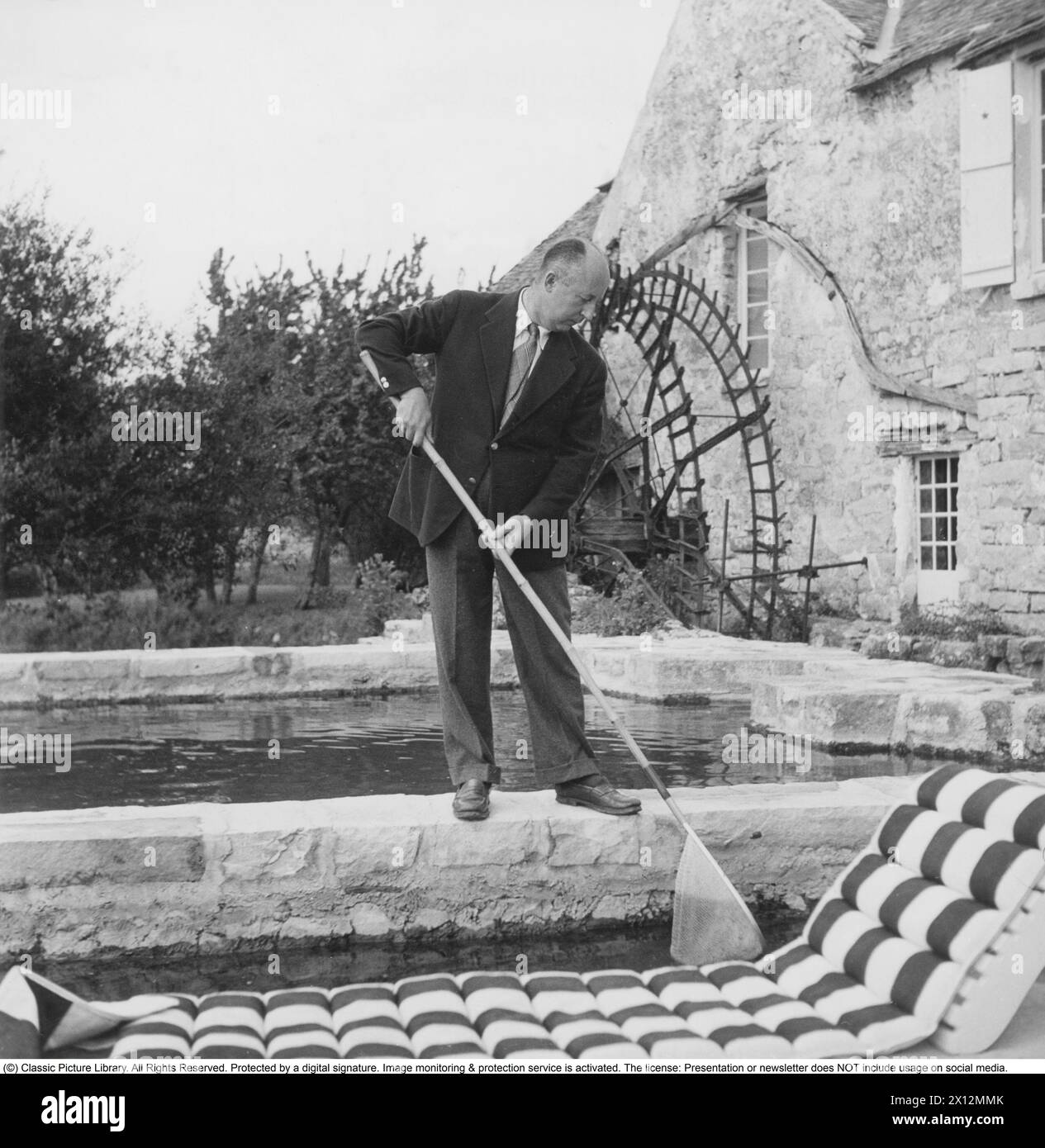 Christian Dior, né le 21 janvier 1905 à Granville en Normandie, mort le 23 octobre 1957 à Montecatini terme en Toscane, est un créateur de mode français. Il est surtout connu pour avoir fondé la maison de couture Dior et créé The New look. Ici, sur sa ferme, un vieux mill. Publié dans Svensk damtidning 1950. Banque D'Images