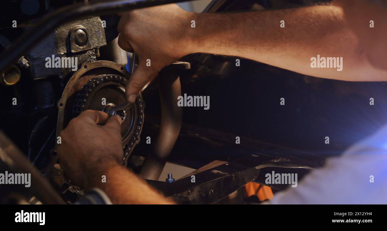 Image de taches lumineuses sur l'homme caucasien réparant la voiture Banque D'Images