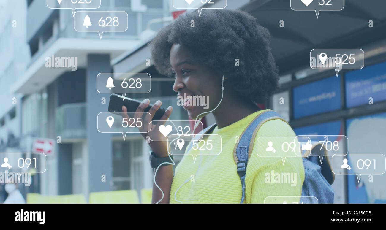 Image d'icônes de médias sociaux sur femme afro-américaine à l'aide d'un smartphone Banque D'Images