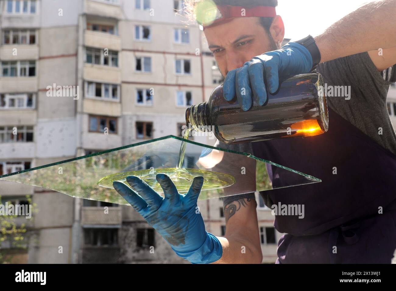 KHARKIV, UKRAINE - 13 AVRIL 2024 - le photographe italien Alessandro parente recouvre le verre des bâtiments détruits par les attaques de missiles russes d'une couche photosensible pour développer une photo des séquelles de l'agression russe en utilisant une technique de photographie du XIXe siècle, Kharkiv, dans le nord-est de l'Ukraine. Banque D'Images