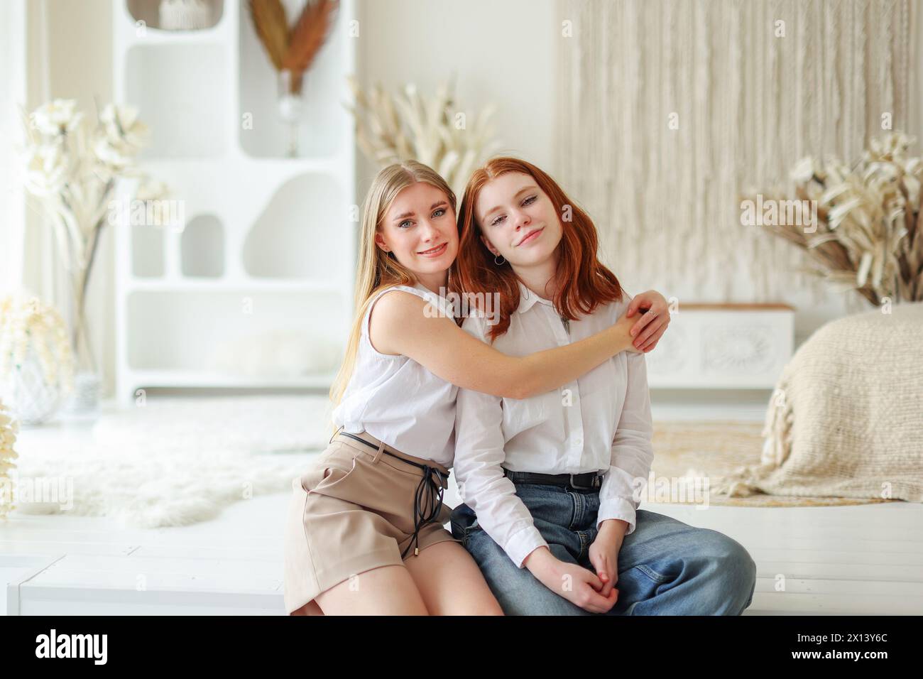 deux sœurs adultes assises dans une étreinte. Amitié féminine, famille Banque D'Images