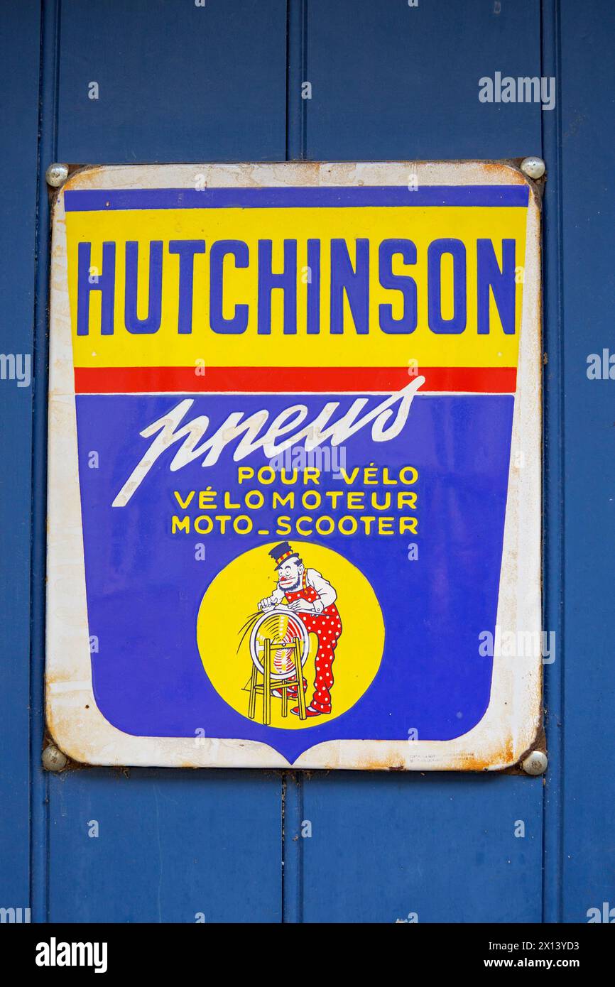 Vieux panneau français faisant la publicité des pneus Hutchinson, avec un clown (souvent une caractéristique des vieilles publicités Hutchinson). Banque D'Images