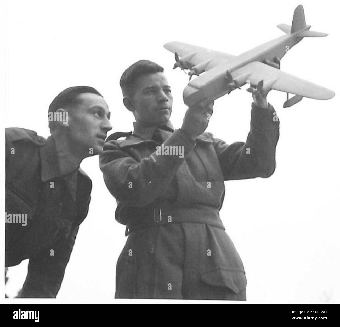 Le sergent D. Ritchie de l'Army Educational corps examine un modèle d'hydravion fabriqué par le soldat G. Jones, R.A.M.C. pendant les activités de Noël dans un hôpital de l'armée britannique. Banque D'Images