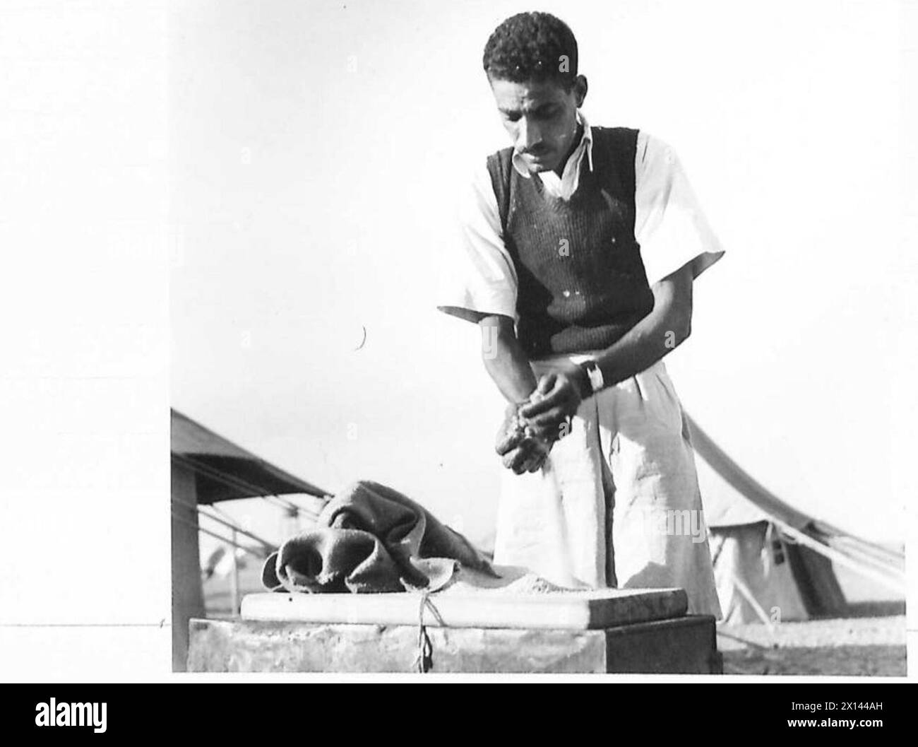 Abdelatif Khalil inspecte le son utilisé comme appât pour la lutte antiacridienne par le corps expéditionnaire britannique au moyen-Orient, traité avec de l'arsénate de sodium. Banque D'Images