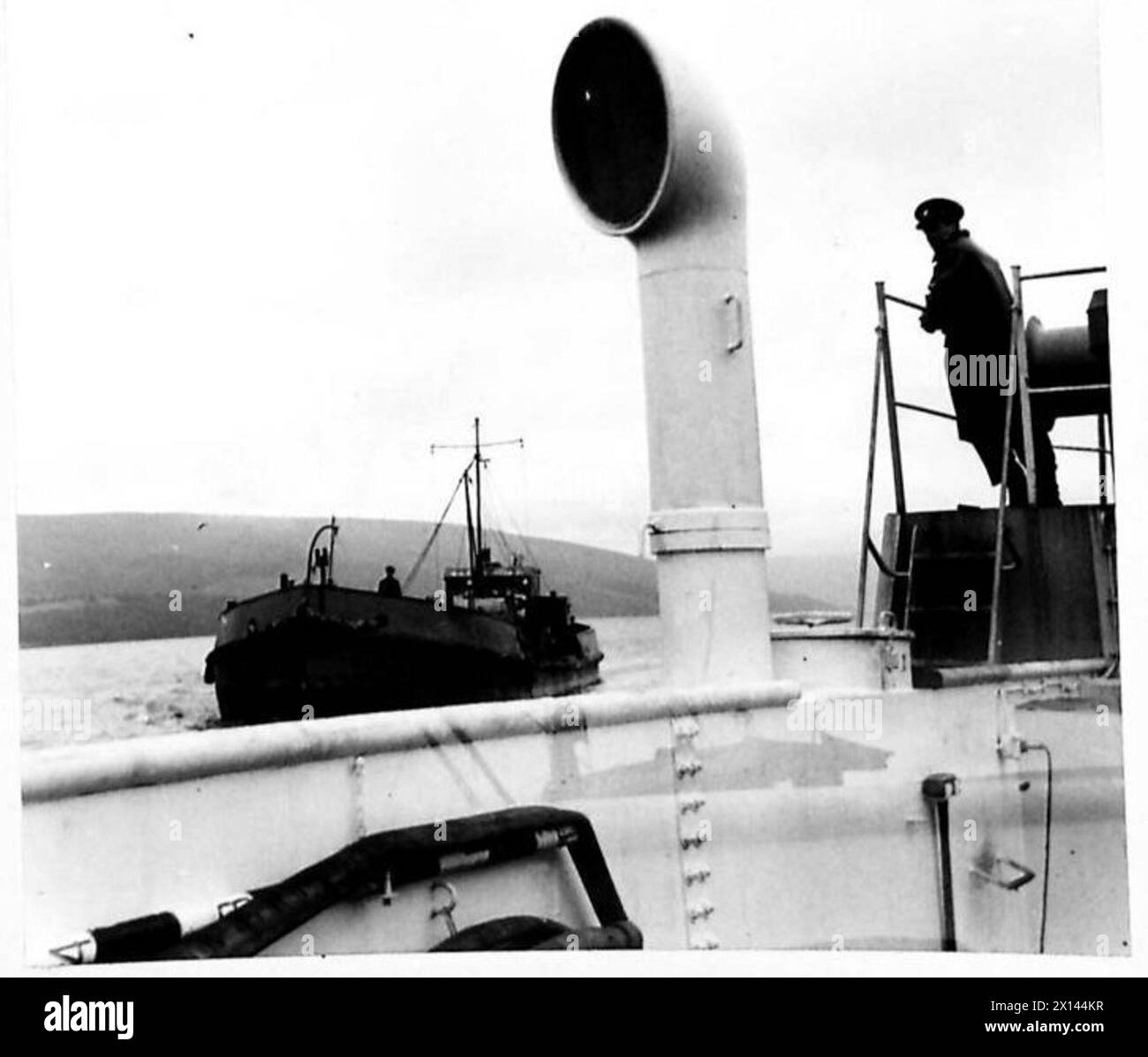 Un bateau d'eau approche et vient à côté d'un Landing Craft Tank (LCT) pendant les opérations de l'armée britannique. Banque D'Images