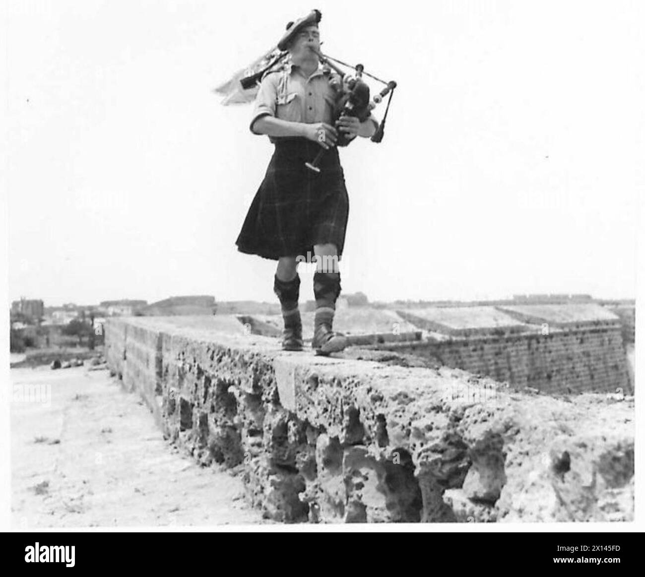 Piper James Wallace Lawson du 11th Scottish Commandos joue de la cornemuse sur les anciens remparts des croisés à Chypre. Banque D'Images
